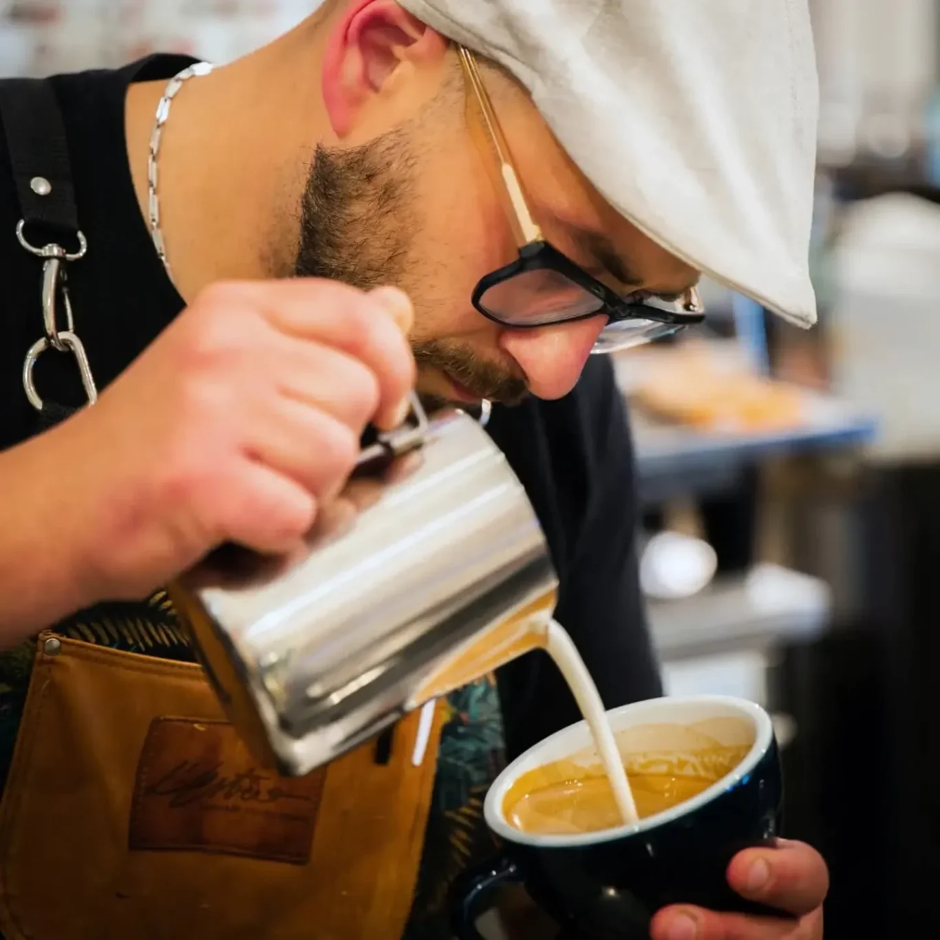 Gianluca Tofani Barista mentre versa latte montato per un cappuccino con latte art. Trainer Corsi con rilascio attestati
